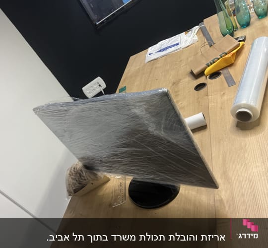 מסך עטוף בניילון על שולחן עם כלים למעבר